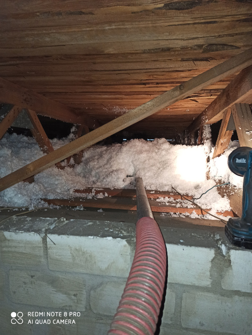 Über Schläuche wird der Flockendämmstoff aufgeblasen